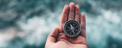 compass in man's hand over water